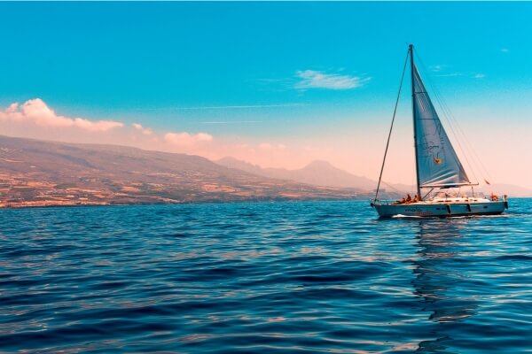 Imagem de um barco navegando em águas cristalinas com uma paisagem deslumbrante ao fundo